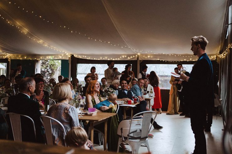 Best man speech at a wedding. A man stood talking to a room full of the reception guests