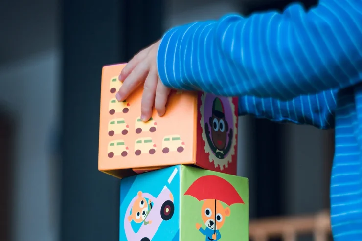 Children's hands stacking colourful cube toys