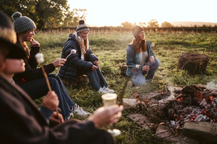 People toasting marshmallows on a fire outside