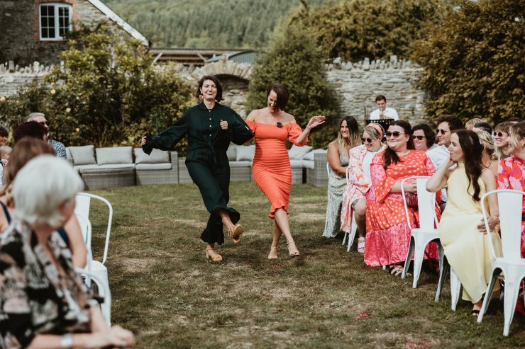 Couple walking down isle outside hand in hand dancing